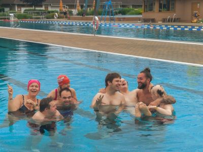 Die Teilnehmenden des Schwimmnachmittags haben Spaß im Schwimmbecken im Außenbereich des Bellamars.